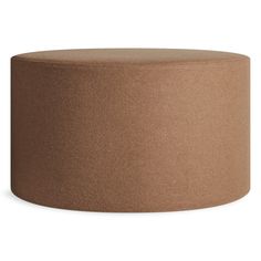 a large brown round ottoman sitting on top of a white floor