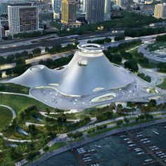 an aerial view of a large building with many trees in the foreground