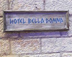 a sign on the side of a building that says hotel bella doma in blue ink