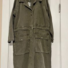 Olive Green Utility Jacket, Knee Length . Has A Baggy Fit, So I’m Guessing Would Fit A Size Large Also. Smoke Free Home Khaki Utility Jacket With Pockets For Layering, Utility Button-up Outerwear For Layering, Long Coat Outerwear With Pockets For Day Out, Long Coat With Pockets For Day Out, Casual Olive Long Coat, Casual Long Utility Jacket For Fall, Olive Collared Outerwear For Spring, Olive Collared Spring Outerwear, Olive Green Utility Jacket