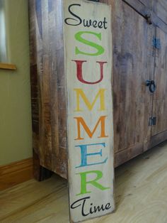 a wooden sign that says, sweet summer time on it next to a large cabinet