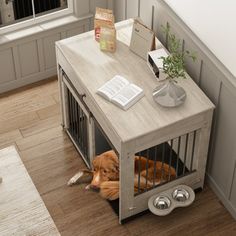 a dog laying on the floor next to a cage with its head in it's mouth