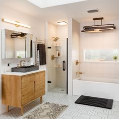 a bathroom with a sink, mirror and bathtub next to a shower stall in the corner