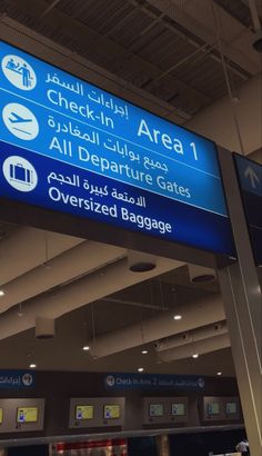 an airport baggage claim area with blue and white signs