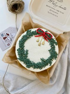 a cake decorated with green and red ribbon on top of a table next to twine of twine