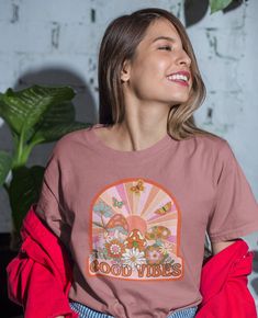 Retro aesthetic sunshine background with mushrooms, butterflies and flowers. This t-shirt is everything you've dreamed of and more. It feels soft and lightweight, with the right amount of stretch. It's comfortable and flattering for all.  *For oversized, relaxed look, size up to your preference. For actual sizing, refer to the size chart. * 100% combed and ring-spun cotton (Heather colors contain polyester) * Fabric weight: 4.2 oz/yd² (142 g/m²) * Pre-shrunk fabric * Side-seamed construction * Shoulder-to-shoulder taping * Blank product sourced from Guatemala, Nicaragua, Mexico, Honduras, or the US This product is made especially for you as soon as you place an order, which is why it takes us a bit longer to deliver it to you. Making products on demand instead of in bulk helps reduce overp Groovy Graphic Print Summer Shirt, Hippie Tops With Funny Print For Spring, Spring Hippie Top With Funny Print, Hippie Top With Funny Print For Spring, Summer Short Sleeve Tops With Mushroom Print, Cotton Shirt With Mushroom Print For Summer, Spring Cotton Tops With Mushroom Print, Spring Cotton Top With Mushroom Print, Summer Cotton Shirt With Mushroom Print