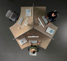 an overhead view of two people working at desks