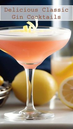 a close up of a drink in a glass on a table with lemons behind it