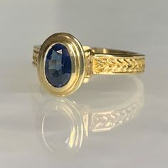 A modern and timeless vintage 14k yellow gold ring featuring an oval shaped sapphire weighing 0.95 carats securely set in a tiered bezel which elevates the stone above the finger with hand crafted detailing along the band. *Ring size: US 6 1/2 * Ring weight: 4.03 grams Gold Oval Cabochon Sapphire Ring For Formal Occasions, Gold Sapphire Ring With Oval Cabochon For Formal Events, Formal Gold Oval Cabochon Sapphire Ring, Formal Gold Sapphire Ring With Oval Cabochon, Luxury 14k Gold Oval Sapphire Ring, Classic Yellow Gold Sapphire Ring Oval Cabochon, Formal 14k Gold Sapphire Ring With Oval Cabochon, Classic Oval Sapphire Ring, Modern Sapphire Ring Oval Cabochon For Formal Occasions