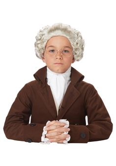 a young boy in a brown coat and glasses with his hands folded over his chest