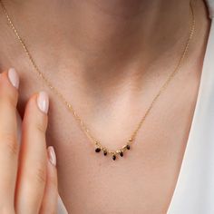 "This dainty onyx necklace is essential to light up your formal look in a delicate way. This onyx station necklace is ultra-light anda good choice for the minimalist jewelry movement. Five tiny black stones hang on a 14 k gold 16,5\" chain. Black stones measures 3mm in width. The adjustable chain with its 1,20\" extender secures with a spring-ring clasp. Due to its delicate design, good care of your jewelry is advised for long use. This onyx necklace is super gift for the women. Would you like t Minimalist Black Spinel Necklaces, Minimalist Black Spinel Necklace, Delicate Black Necklace For Gift, Elegant Black Bead Necklaces For Gift, Elegant Black Diamond Necklaces For Anniversary, Elegant Black Beads Necklace For Gift, Black Dainty Jewelry For Party, Elegant Black Diamond Necklaces, Elegant Black Spinel Necklace For Formal Occasions