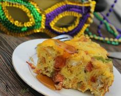 a piece of food on a plate with some mardi gras beads in the background