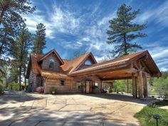 a large house surrounded by trees on a sunny day