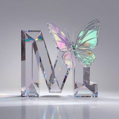 a butterfly sitting on top of a crystal letter m with its wings spread wide open