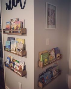 three wooden bookshelves with children's books on them in the corner of a room