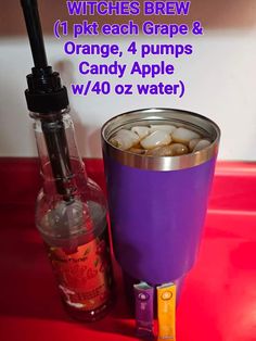 an orange and purple drink in a glass next to a bottle