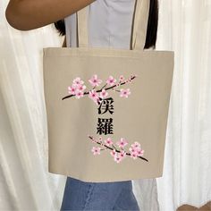 Embrace the elegance of Japanese tradition with our handmade tote bag adorned with a graceful cherry blossom design. Personalize your bag with your name in Japanese, choosing from Hiragana, Katakana, or Kanji characters. Each bag is crafted with love and care, featuring hand-drawn art by me, ensuring a truly unique piece that reflects your individual style. Perfect for those who cherish Japanese culture,  this unique tote bag is sure to turn heads and make a statement wherever you go As a Japane Kawaii Beige Bag As Gift, Kawaii Beige Bag For Gift, Kawaii Beige Bags Perfect For Gifts, Travel Anime, Your Name In Japanese, Japanese Tote Bag, Hiragana Katakana, Name In Japanese, Kanji Characters