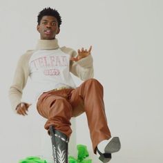 a young man riding a skateboard on top of a green and white object with his hands in the air