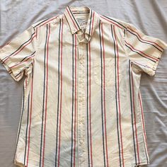 J. Crew Short Sleeve Button Button Up 98% Organic Cotton 2% Elestane Size Small Creamish Color With Red And Blue Stripes Pretty Much Brand New. No Holes, Rips, Or Stains Pit To Pit Measurement: 20 Inches Shoulder To Hem Measurement: 27 Inches Fitted Casual Shirt With Buttoned Pockets, Everyday Button-up Shirt With Buttoned Pockets, Business Casual Button-up Tops With Button Closure, Classic Summer Shirt With Back Button Closure, Classic White Shirt With Buttoned Pockets, Casual Button-up Tops With Buttoned Pockets, White Cotton Shirt With Buttoned Pockets, Business Casual Button-up Top, Casual Collared Shirt With Back Button Closure