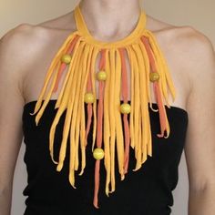 a woman wearing an orange and yellow necklace with beads on it's neck,