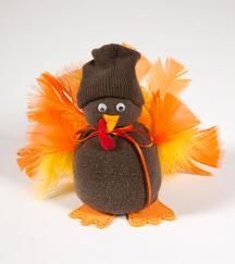 a stuffed toy penguin wearing a hat and orange feathers