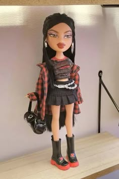 a doll with black hair and boots on a shelf