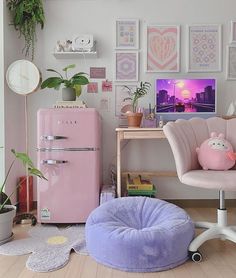 a cat is sitting in a pet bed next to a pink refrigerator and some pictures on the wall