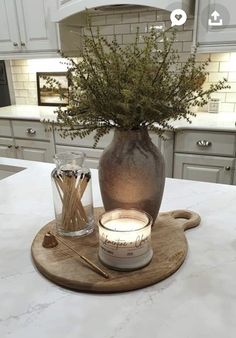 a kitchen counter with a vase and candle on it, surrounded by utensils