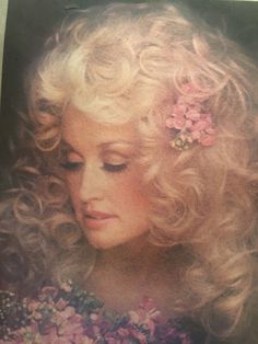 an old photo of a woman with blonde hair and flowers in her hair looking down