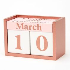 a pink and white wooden calendar with the date march 10