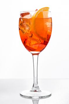 an orange drink in a wine glass with ice