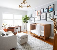 a baby's room with a giraffe statue and pictures on the wall