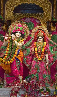 two statues of hindu deities in front of a shrine