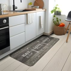 a kitchen area with a stove, sink and oven doormat that says happy new year