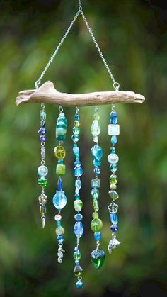 a wind chime hanging from a tree branch filled with glass beads and other items