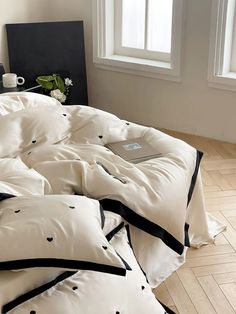 an unmade bed with black and white pillows