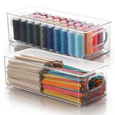 two clear acrylic storage containers filled with different colored spools of thread