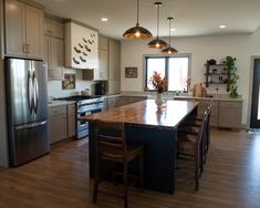 a kitchen with wooden floors and stainless steel appliances