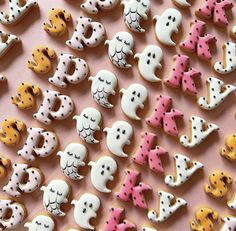 there are many decorated cookies that look like ghost's and cats on the table