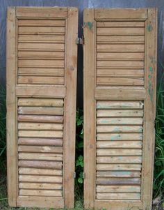 two wooden doors with shutters open in the grass