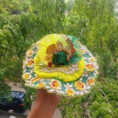 a person holding up a paper plate with a decoration on it