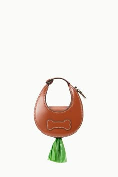 a brown handbag with a dog bone on the front and green ribbon around it