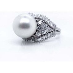 Imagine stepping into a time machine and being transported back to the glamorous 1960s. As you adorn your hand with our exquisite Platinum Pearl & Diamond Ring, you'll instantly feel like a vintage fashion icon. This stunning cocktail ring captures the essence of timeless elegance with its captivating design.Crafted in the 1960s, this ring is a true piece of history, handcrafted with meticulous attention to detail. The centerpiece is a lustrous white pearl, measuring an impressive 12.5mm in diam Luxury White Diamond Ring For Party, Elegant Evening Rings With Center Stone, Elegant White Ring For Evening Occasions, Elegant White Ring For Evening, Elegant White Evening Ring, Luxury Diamond Ring With Center Stone For Party, Elegant Brilliant Cut Diamond Ring For Party, Elegant Diamond Ring For Party, White Diamond Rings For Evening