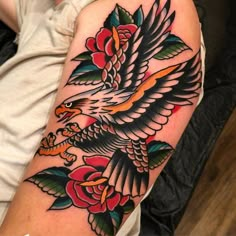 an eagle and roses tattoo on the arm