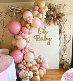 the balloon arch is decorated with pink, gold and white balloons