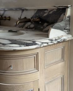 a bathroom vanity with marble top and drawers