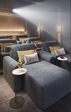 a room filled with lots of gray couches next to a wall mounted projector