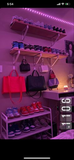 shoes and handbags are displayed on shelves in a room with purple lighting behind them