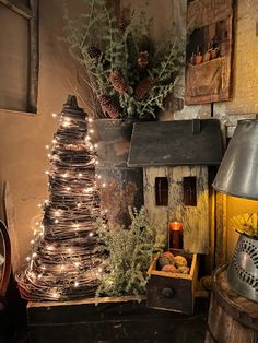 a christmas tree with lights on it in front of a wooden box and other decorations