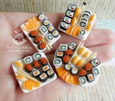 four miniature sushi on sticks in the palm of someone's hand